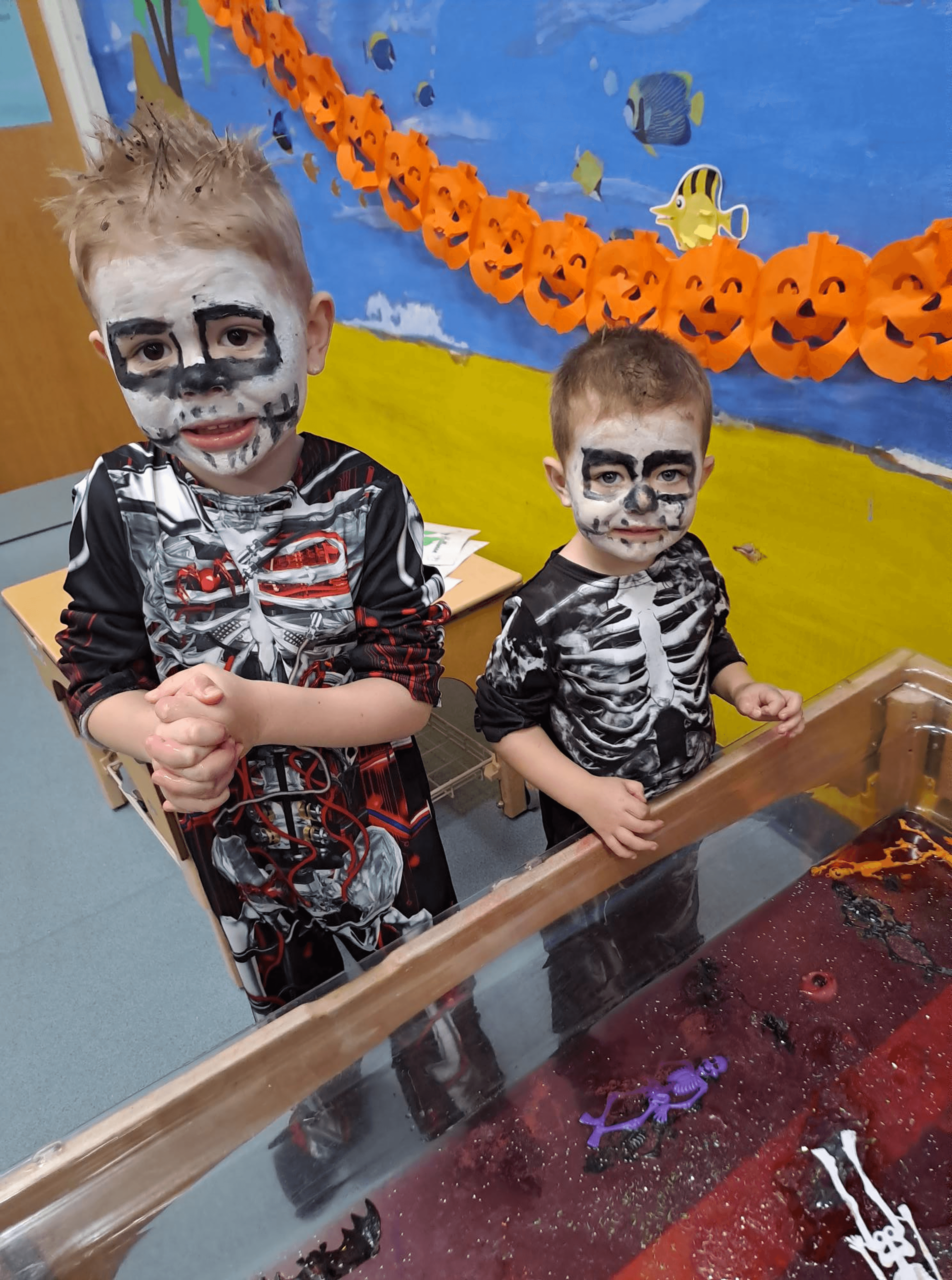 2 boys dressed as skeletons playing in jelly