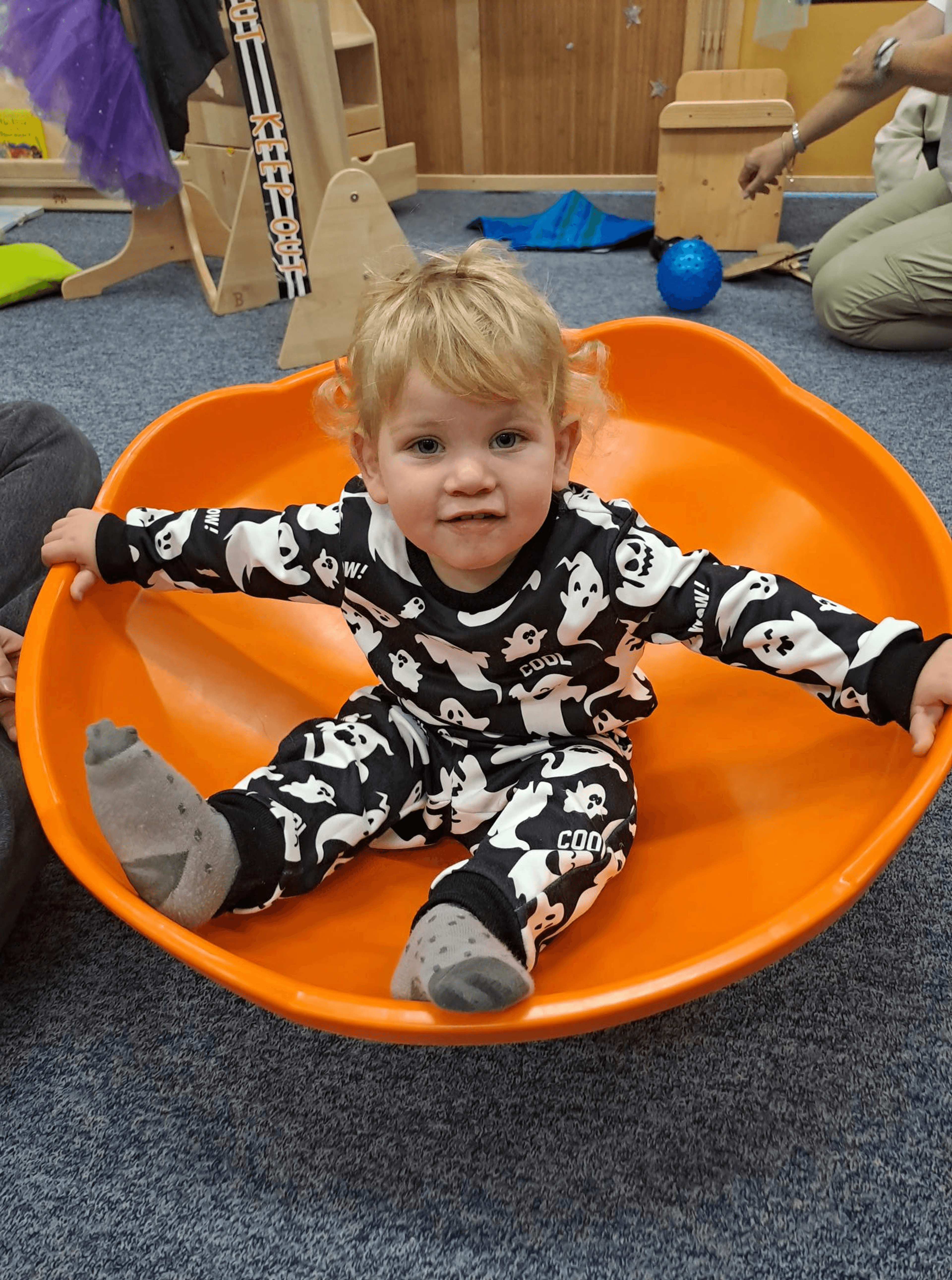 Child in an orange plastic spinner