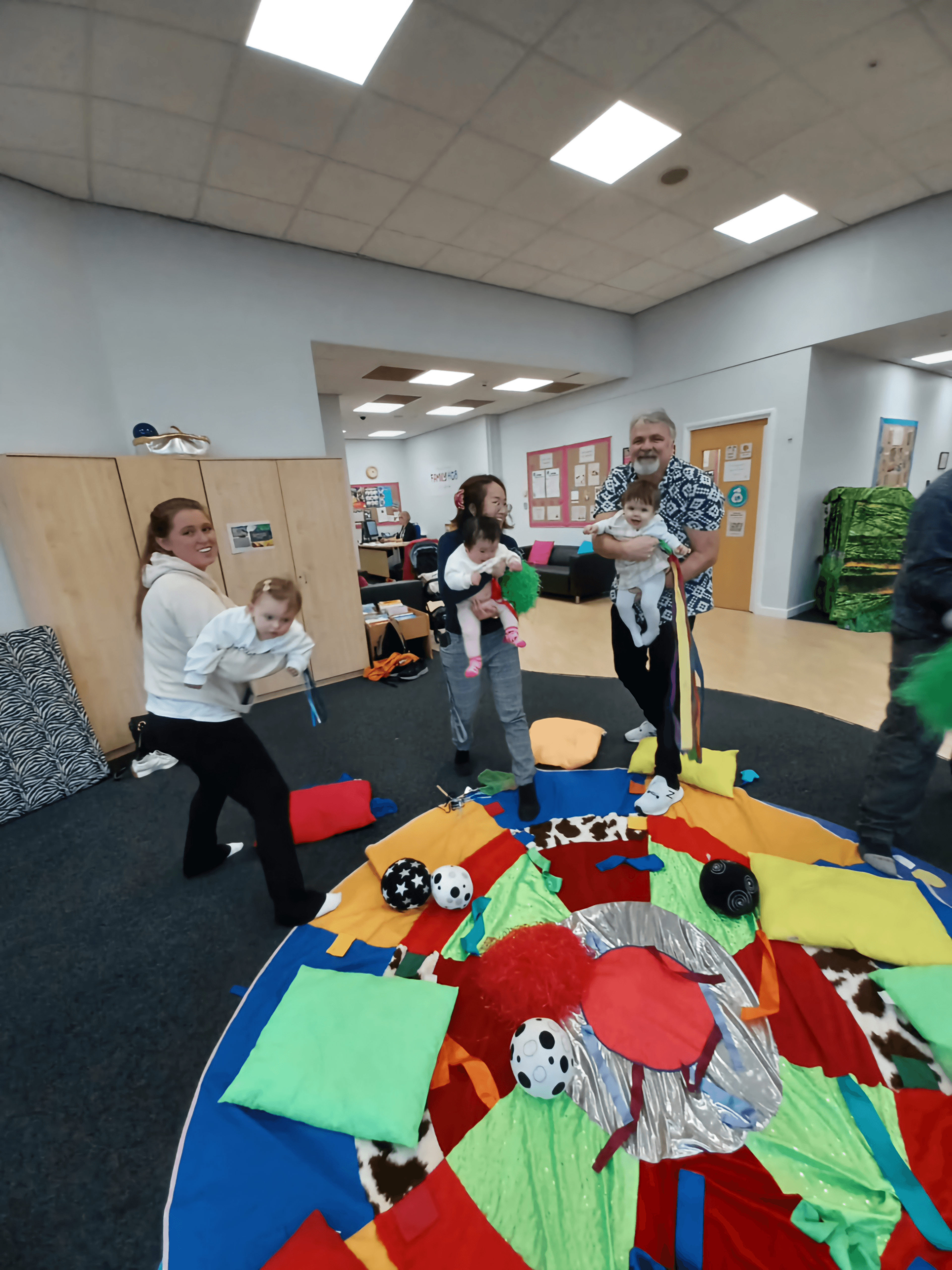 parents carrying children in a movement session