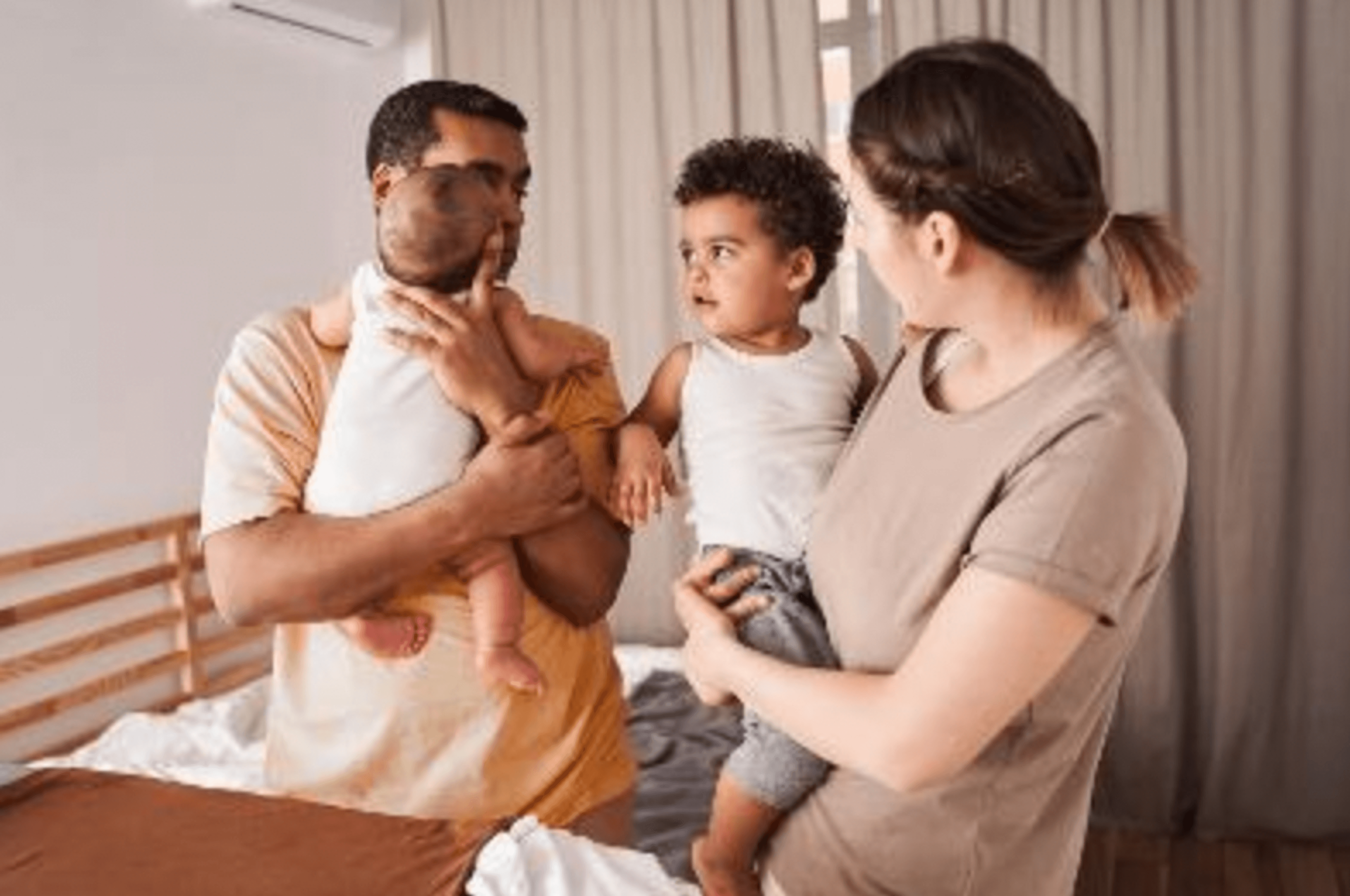 image of two parents each holding young children
